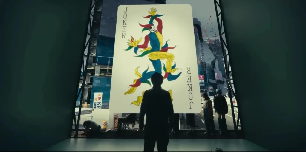 A man stands before a large joker card, symbolizing the final game in Alice in Borderland Season 3.