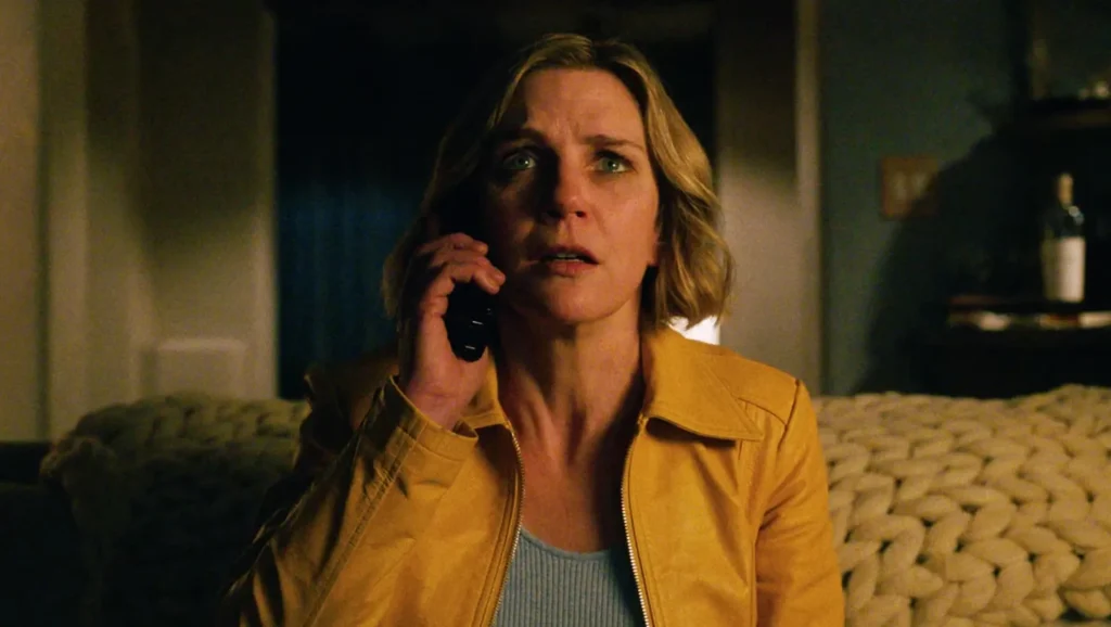 A woman, visibly frightened, answers a phone call, capturing the suspenseful atmosphere of the sci-fi series Pluribus.