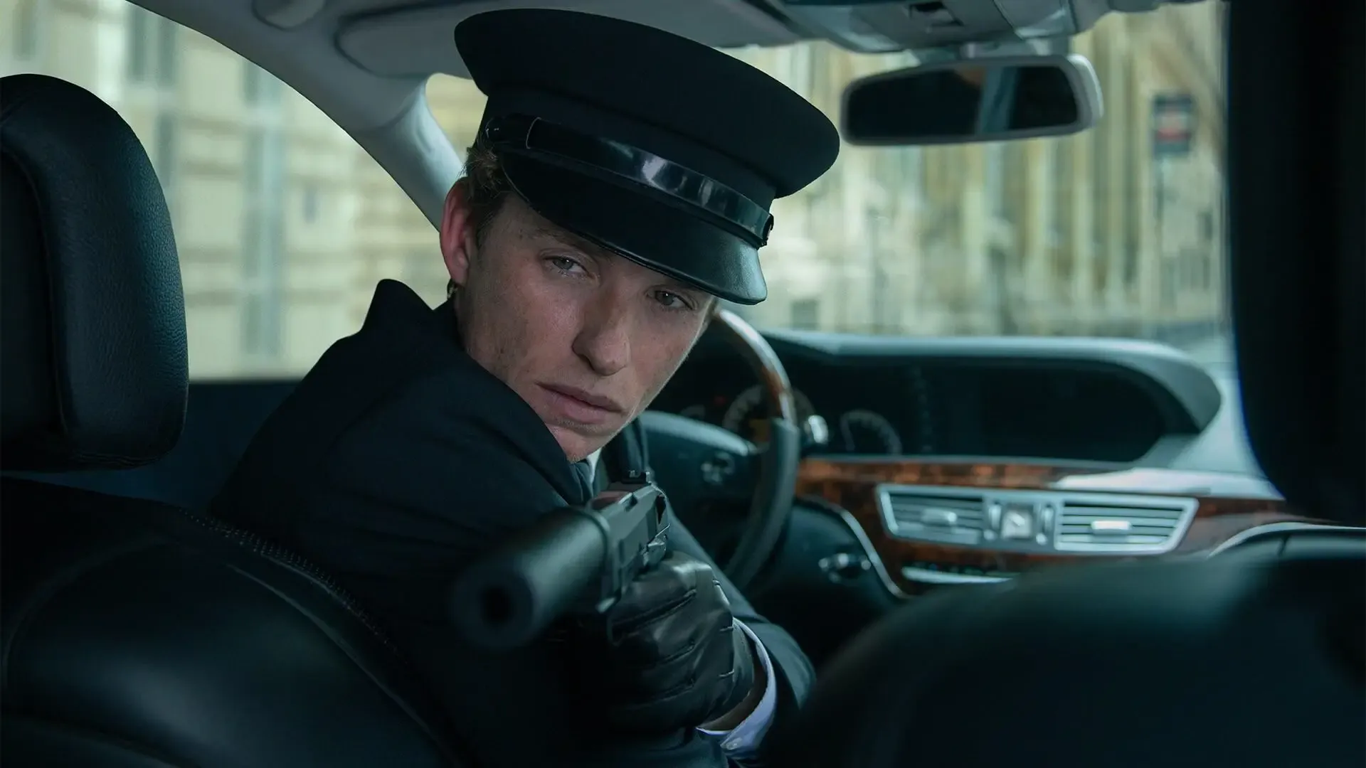 A man in black holds a gun, representing a scene from "The Day of the Jackal" series.